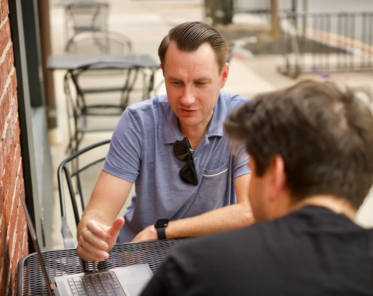 Lee Procida meeting with a client at a café table in Haddonfield